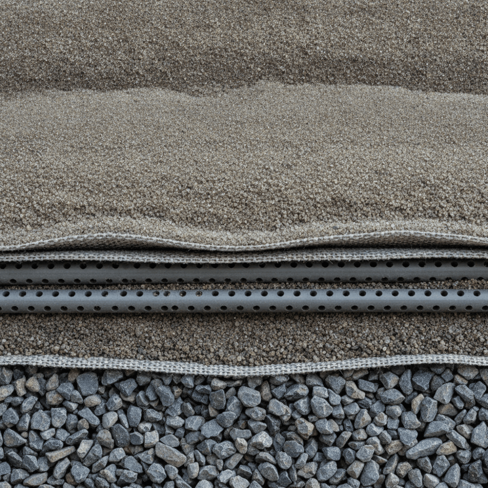 Coupe transversale d'un filtre à sable pour fosse toutes eaux montrant les couches de gravier et sable pour traitement des eaux usées