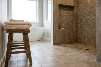 Salle de bain moderne avec carrelage grand format en grès cérame greige et mosaïque décorative dans la niche de douche